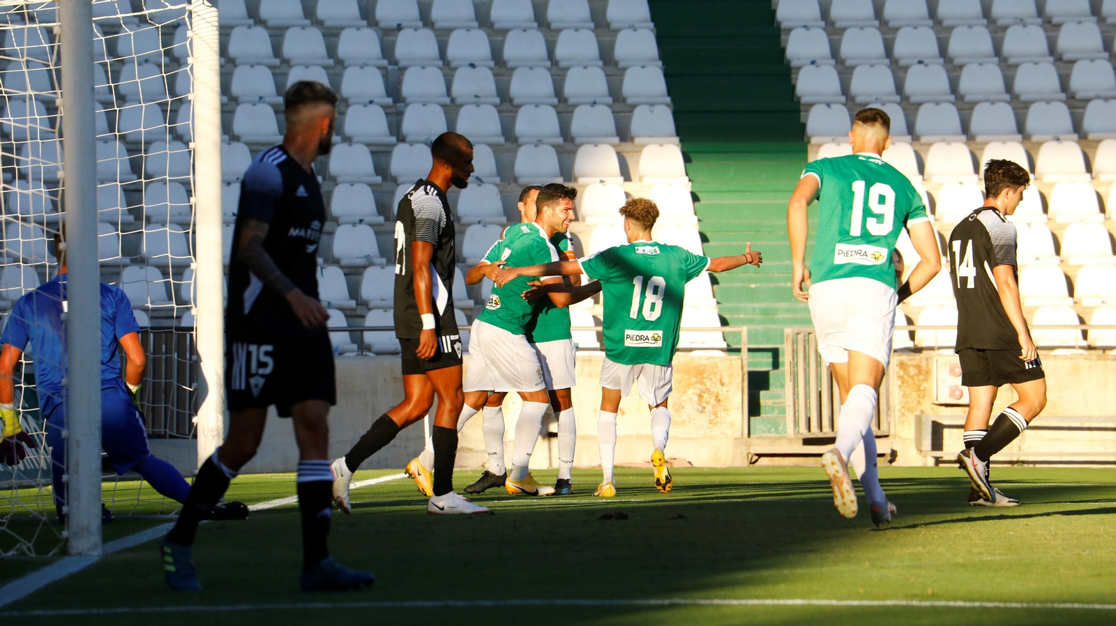 Willy sonríe, abrazado por sus compañeros, tras anotar su primer gol al Marbella.