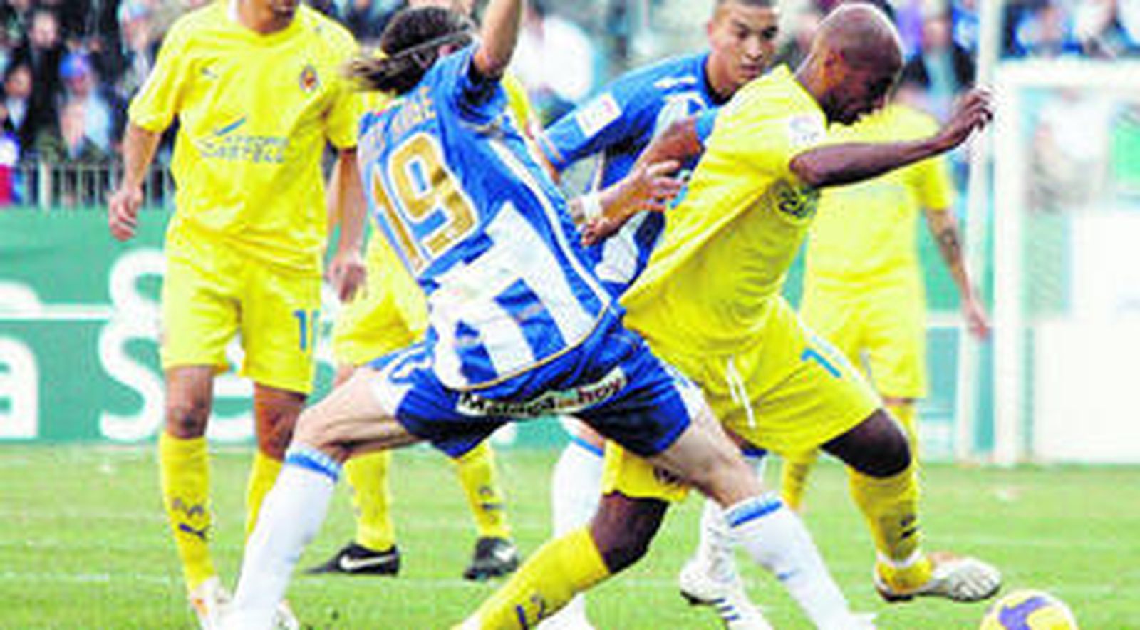 El jugador del Villarreal Marcos Senna controla el balón ante el malaguista Miguel Ángel.