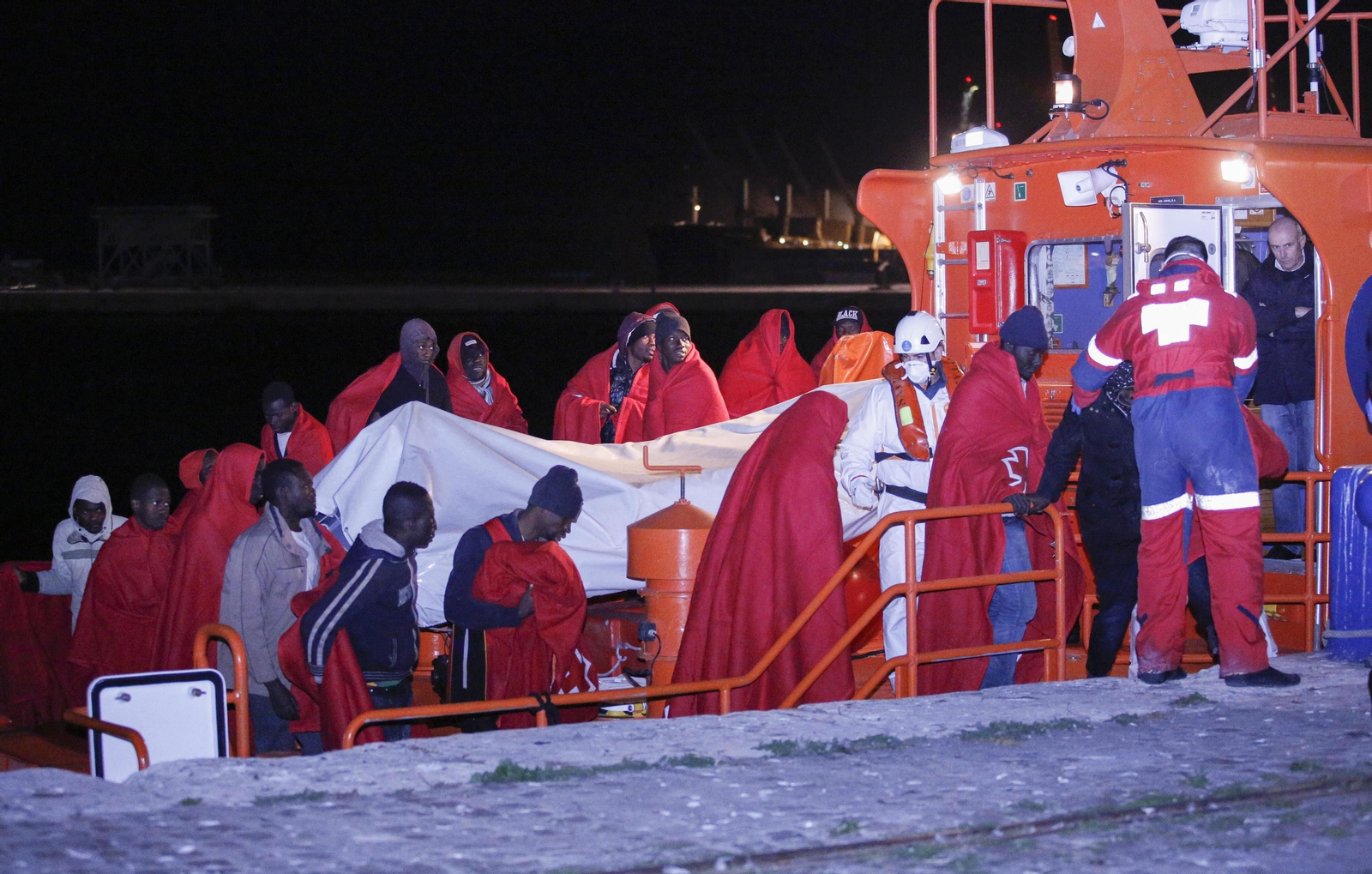 Personas rescatadas, ayer, de una de las pateras a su llegada al puerto de Málaga.