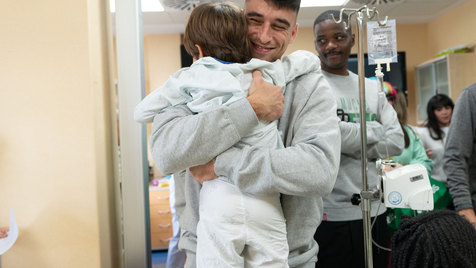 Marc Roca de abraza con un niño.