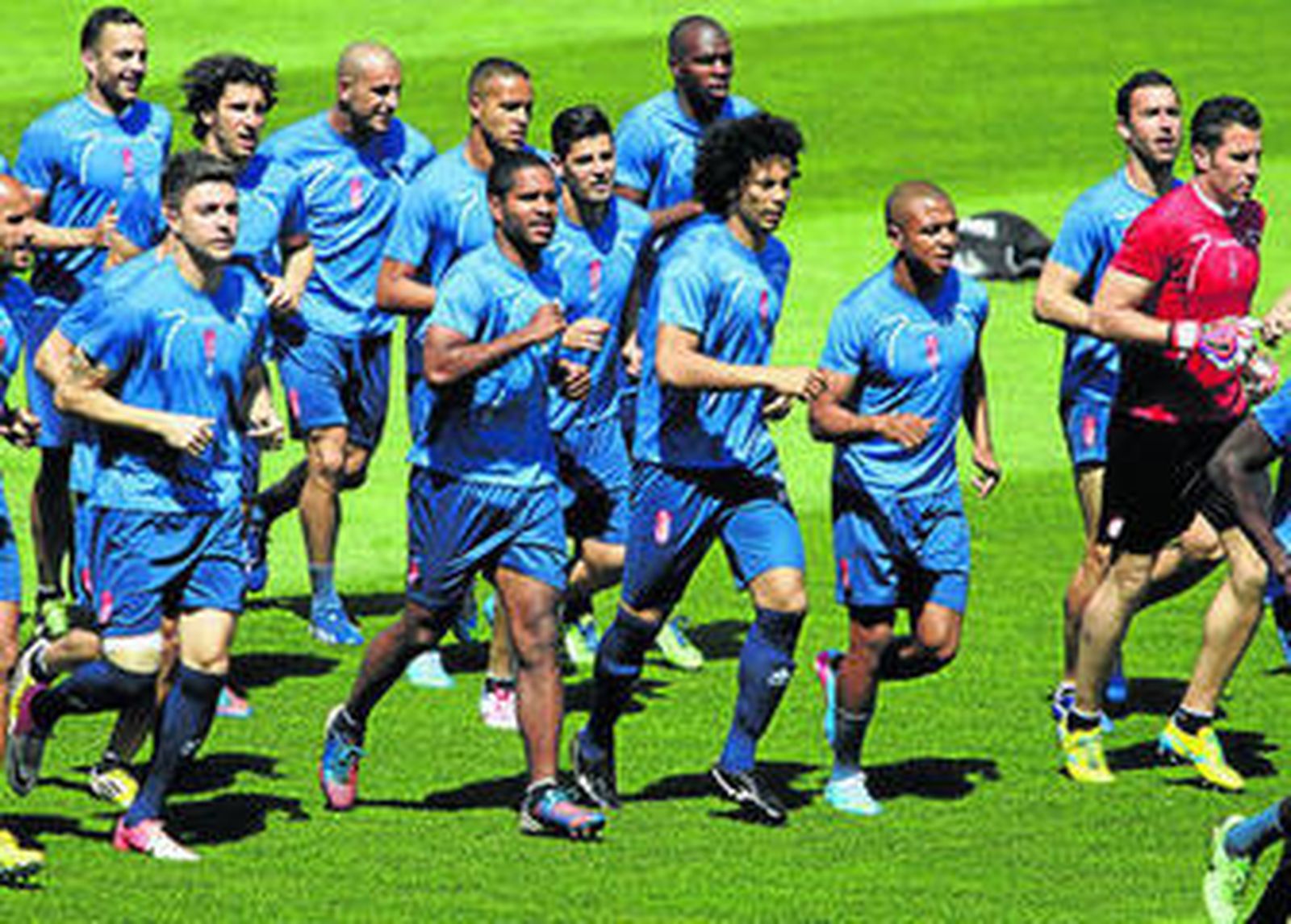 Los futbolistas del Granada CF trotan sobre el césped.