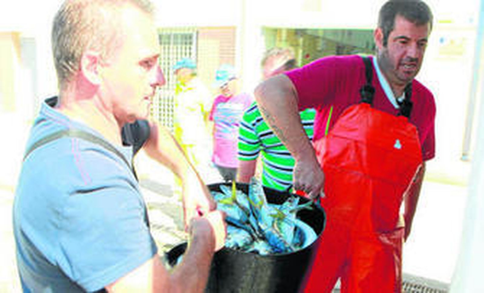 Pescadores llevan su mercancía a la lonja de La Línea.