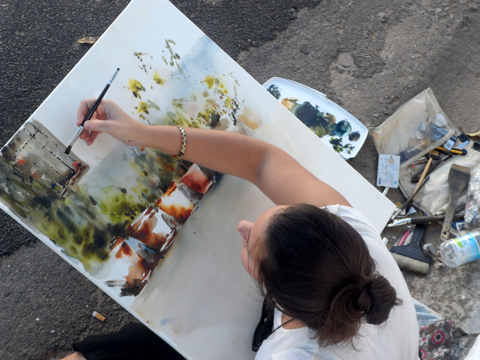 Una joven realiza una obra en el certamen de pintura al aire libre de Cortelazor la Real.