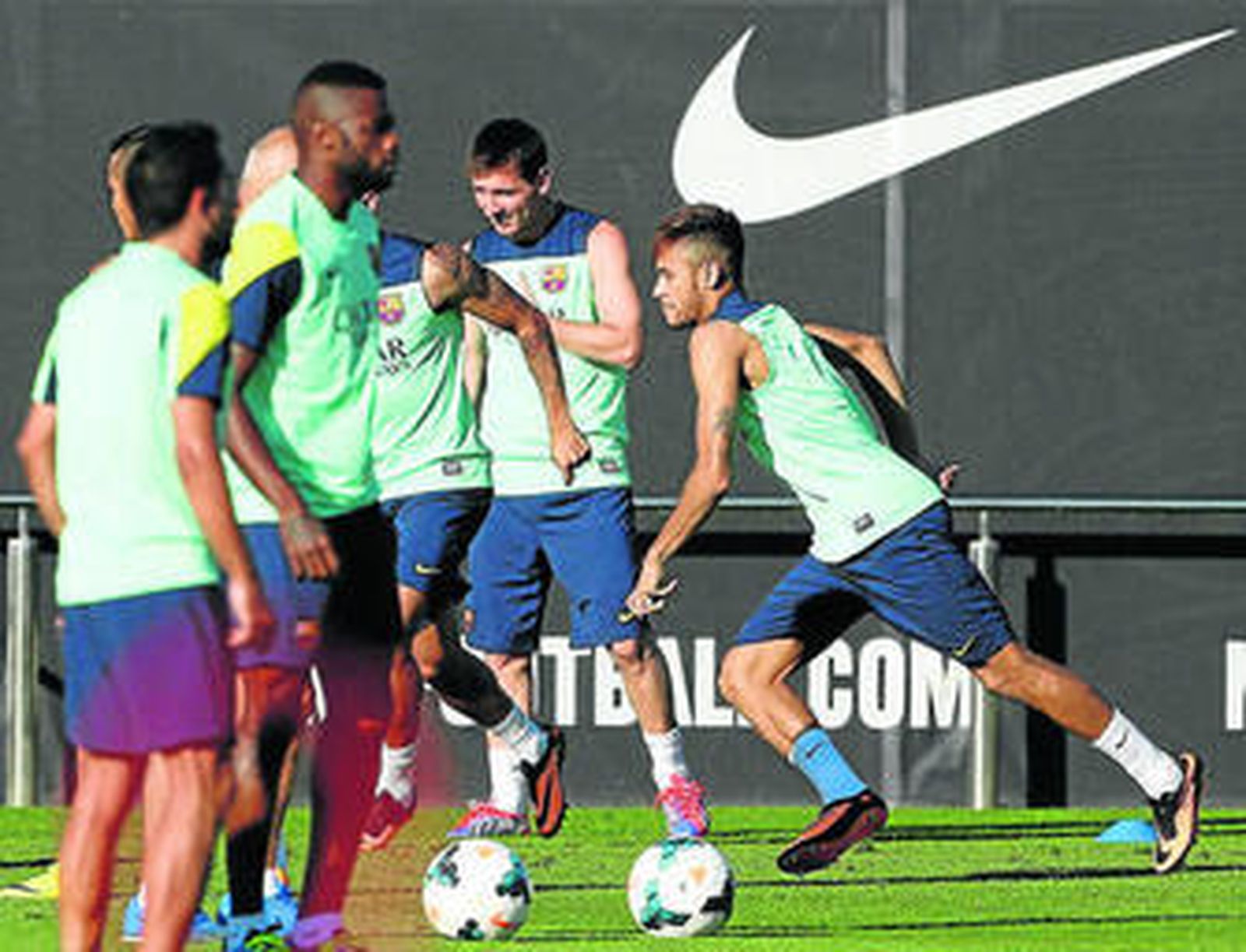 Neymar, con Messi al fondo en el primer entrenamiento del brasileño con el Barcelona.