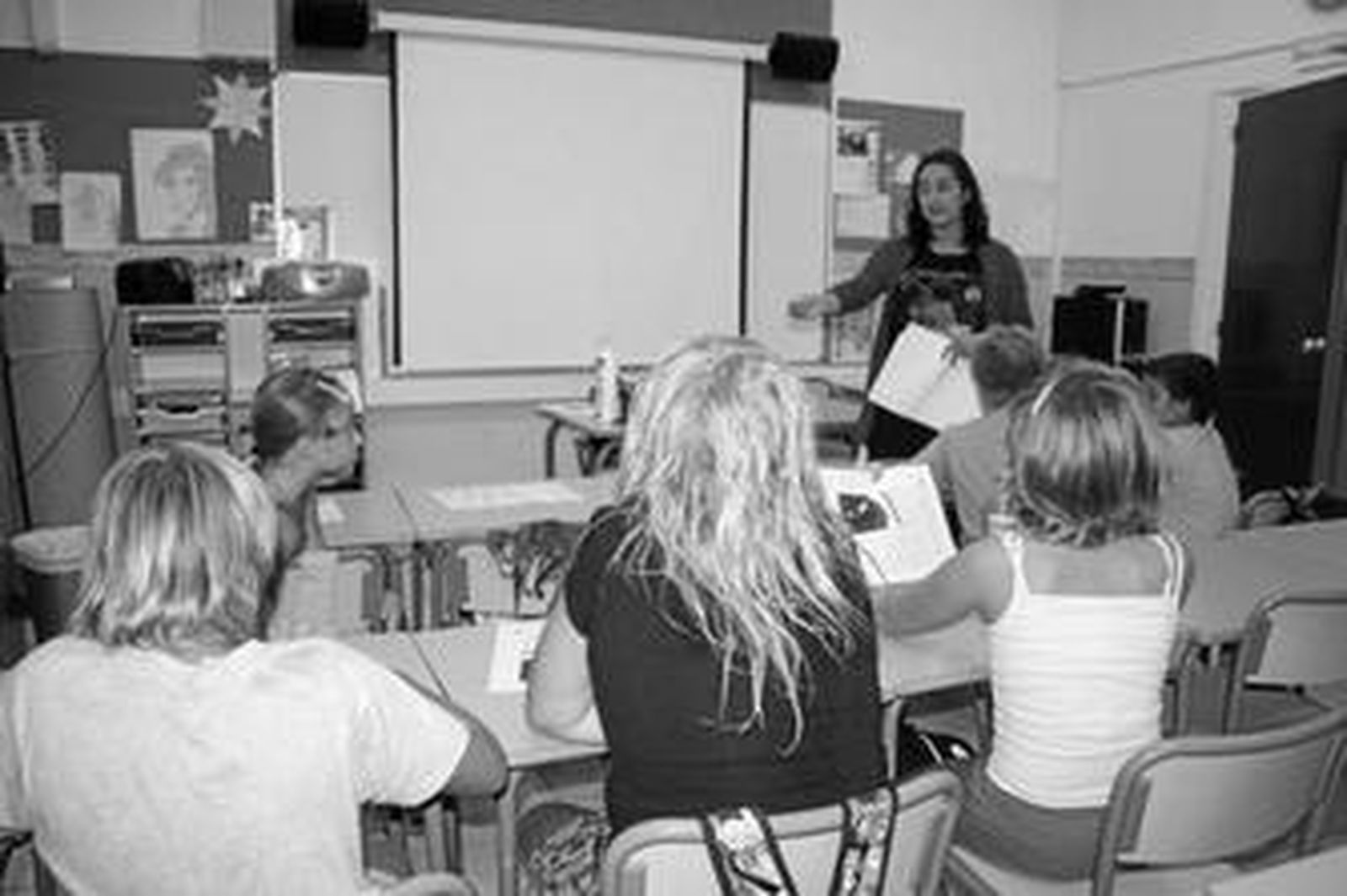 Una profesora imparte clases a un grupo de alumnos.