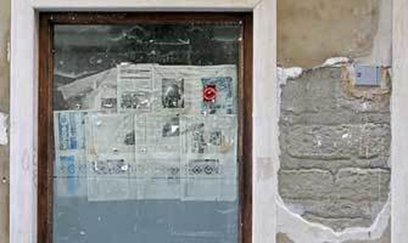 El escaparate de un local cerrado luce empapelado con ejemplares de Diario de Cádiz. /Julio González