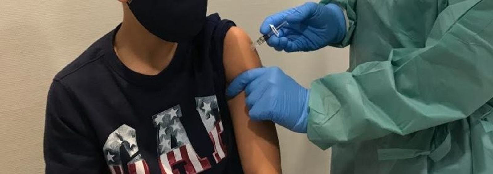 Una enfermera vacuna a un joven contra la gripe.