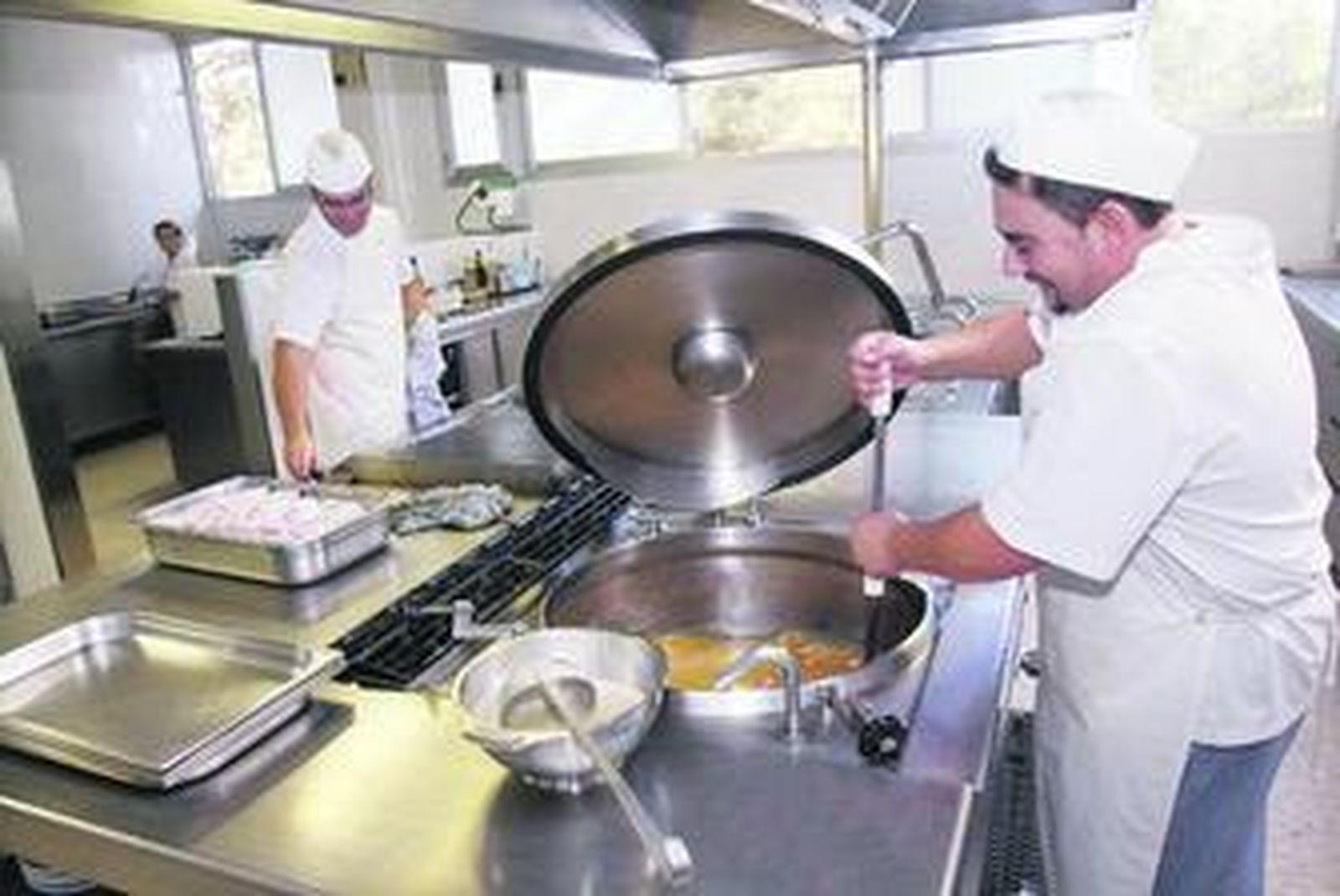 Cocineros del colegio Los Olivos comienzan a preparar el menú del día a base de sopa y pescado.