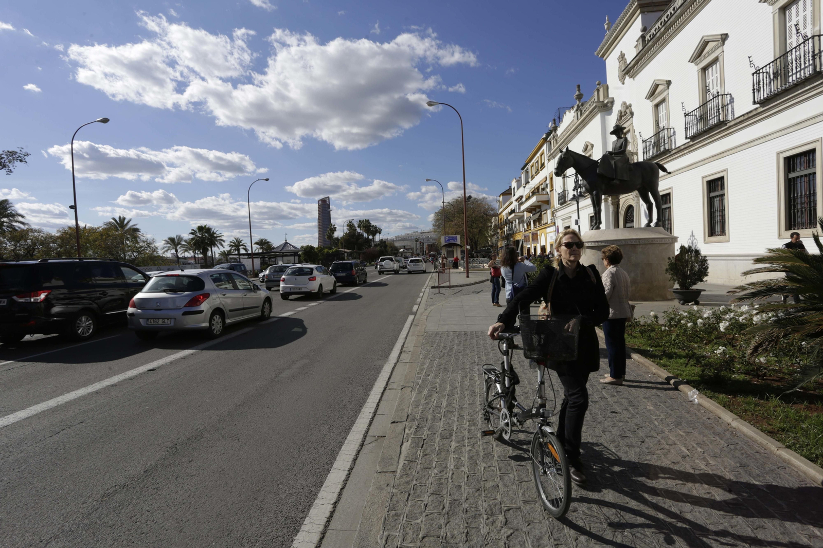 Una mujer pasa con su bicicleta junto al monumento a la Condesa de Barcelona, junto a la plaza de toros.