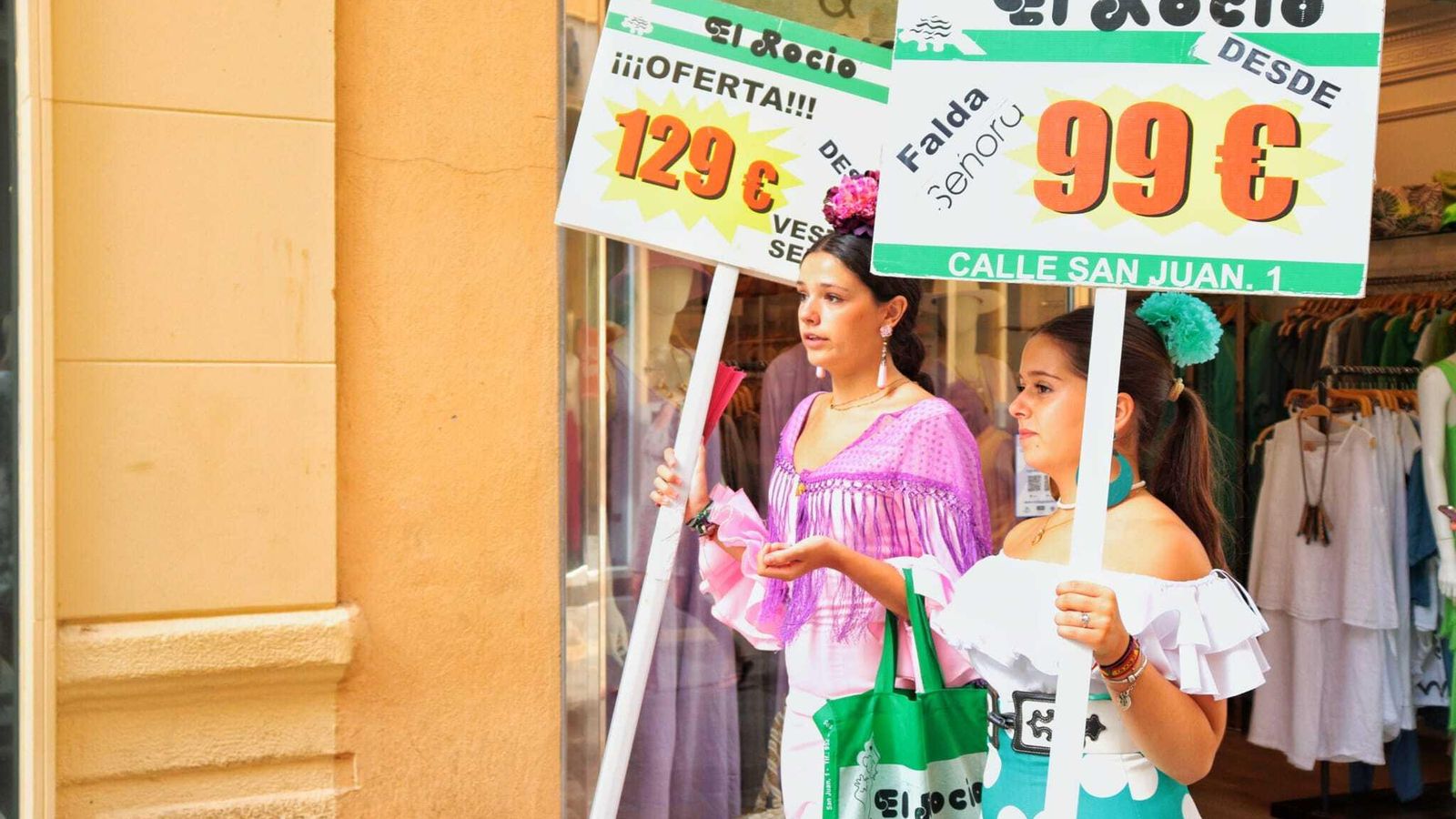 Dos muchachas vestidas de flamenca publicitando los vestidos