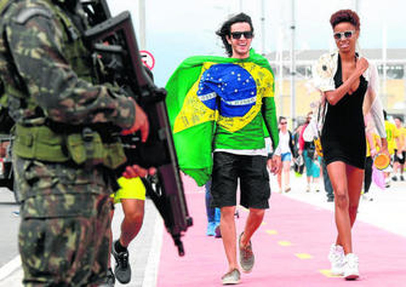 Un militar vigila una de las sedes de Río ante la presencia de varios seguidores cariocas.