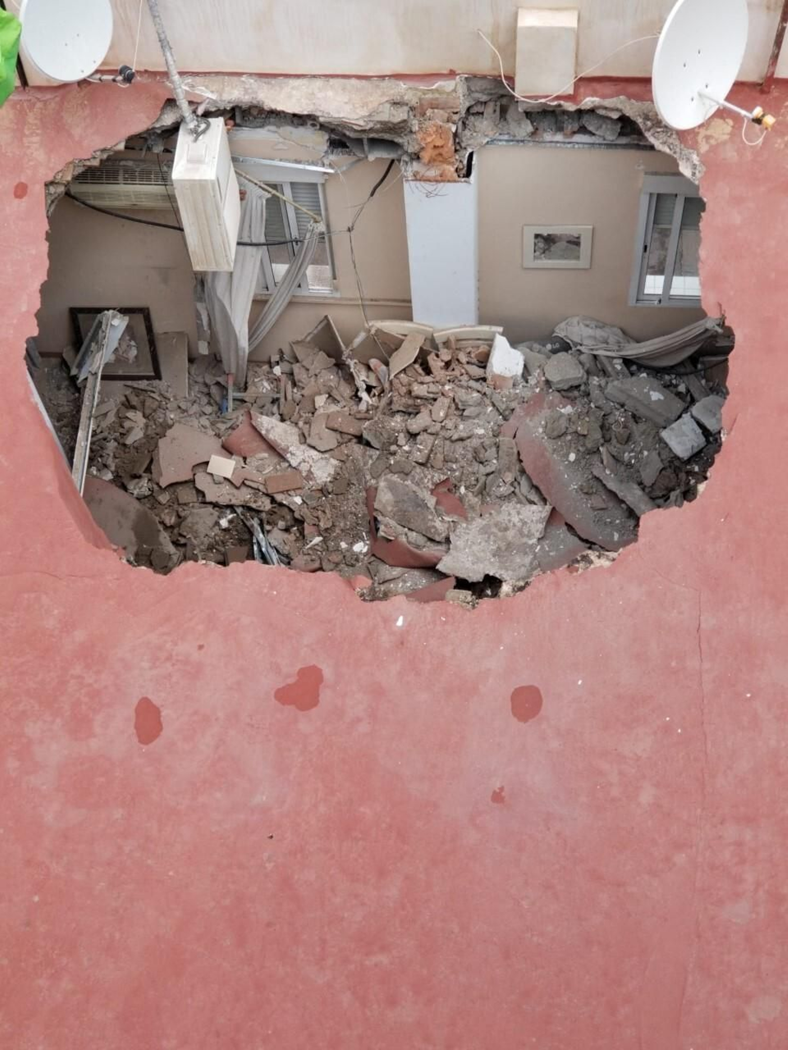 Agujero que se ha hecho en el forjado del terrado y cuyos escombros han caído sobre la vivienda del último piso del edificio, de tres plantas