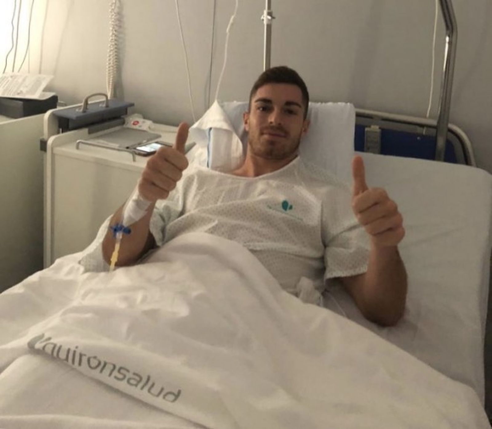El cadista alza sus pulgares desde la cama del hospital.