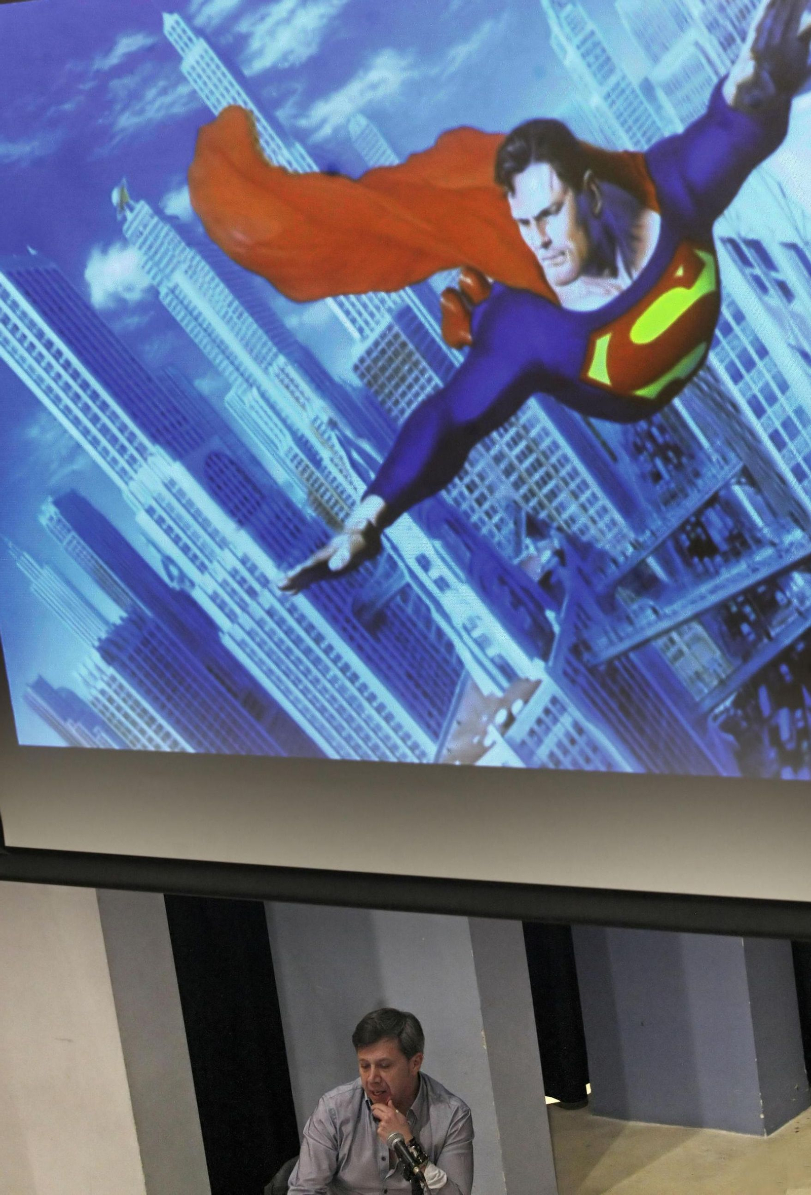 Carlos Pacheco, bajo una imagen de Superman. Carlos Pacheco, bajo una imagen de Superman.