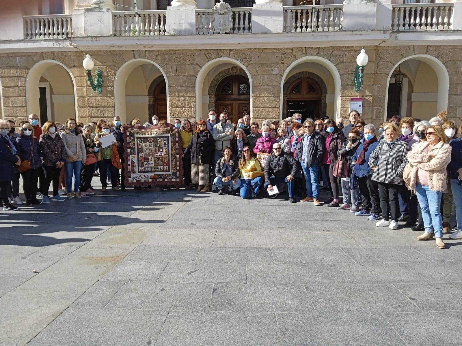Un buen número de usuarios de los talleres concentrados ante el Ayuntamiento de Cádiz.