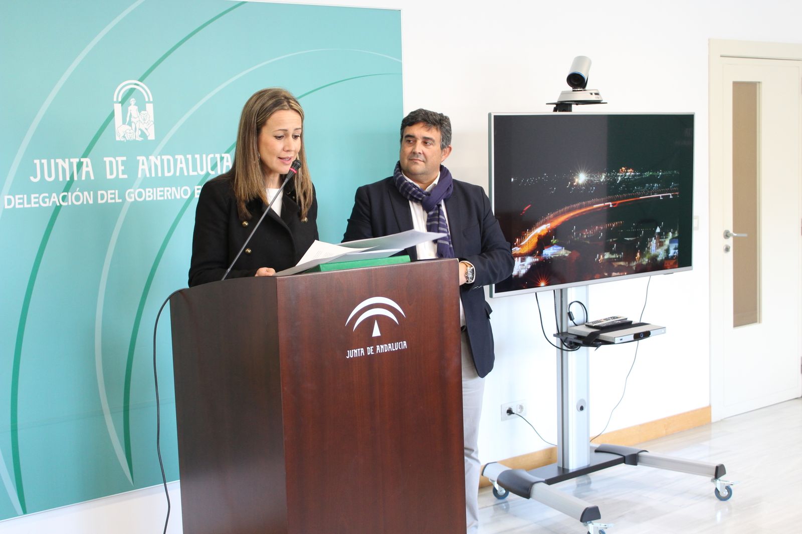 La delegada del Gobierno, Bella Verano, y el delegado de Fomento, José Correa, con el puente iluminado al lado.