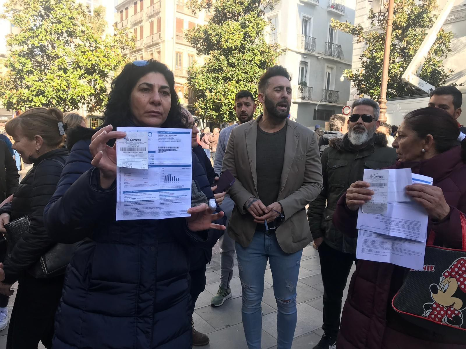 Dos de las vecinas muestran los recibos de la luz.