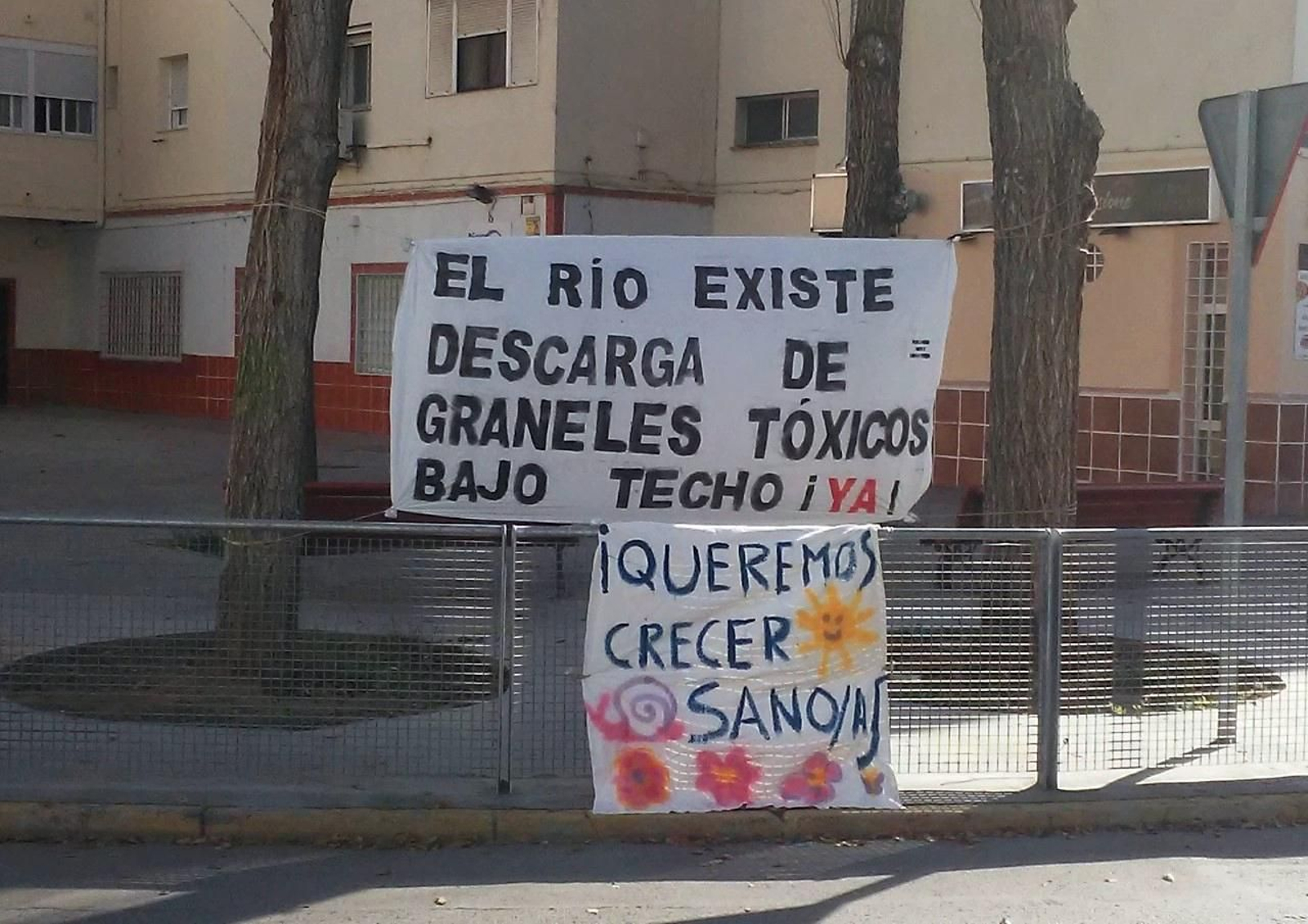 Una de las pancartas colocadas en el barrio contra la descarga de graneles a cielo abierto