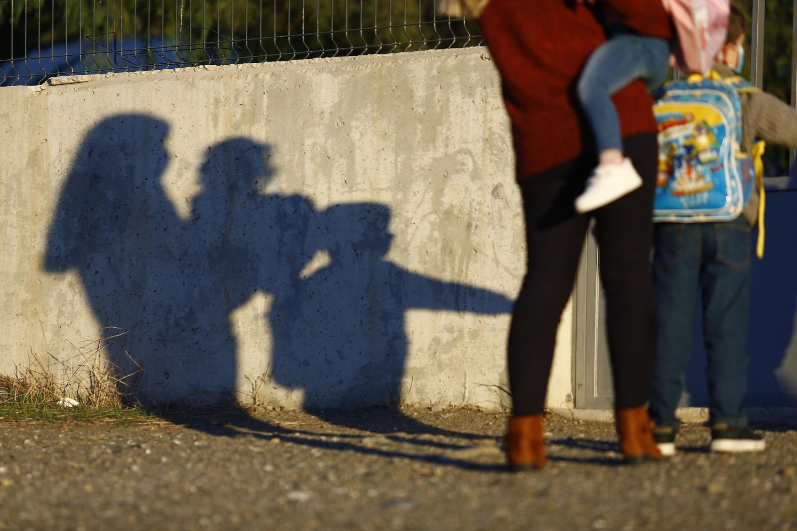 Una madre acompaña a sus hijos en la vuelta a clase tras la Navidad.