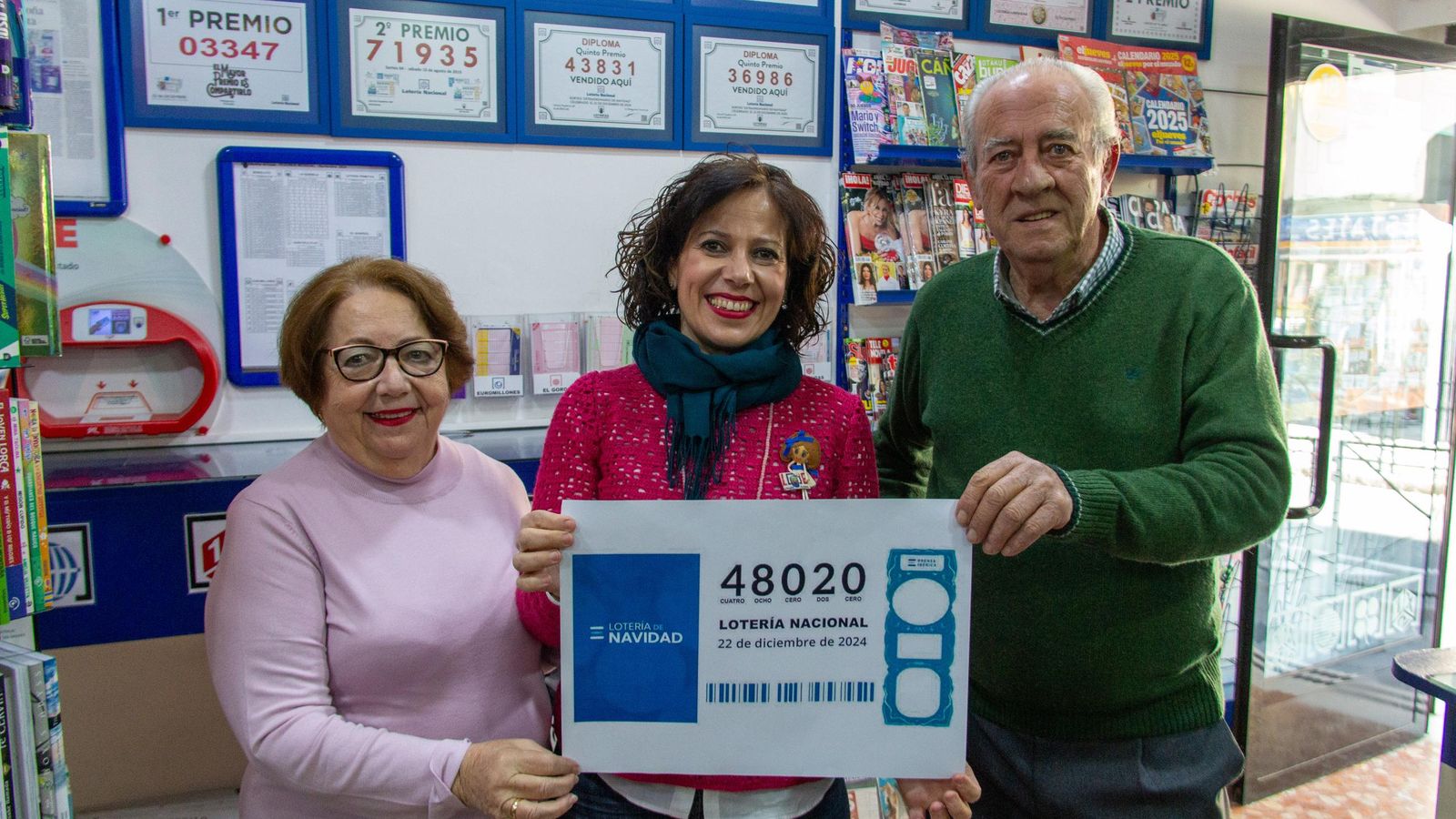 María Teresa junto a sus padres agarrando el décimo premiado