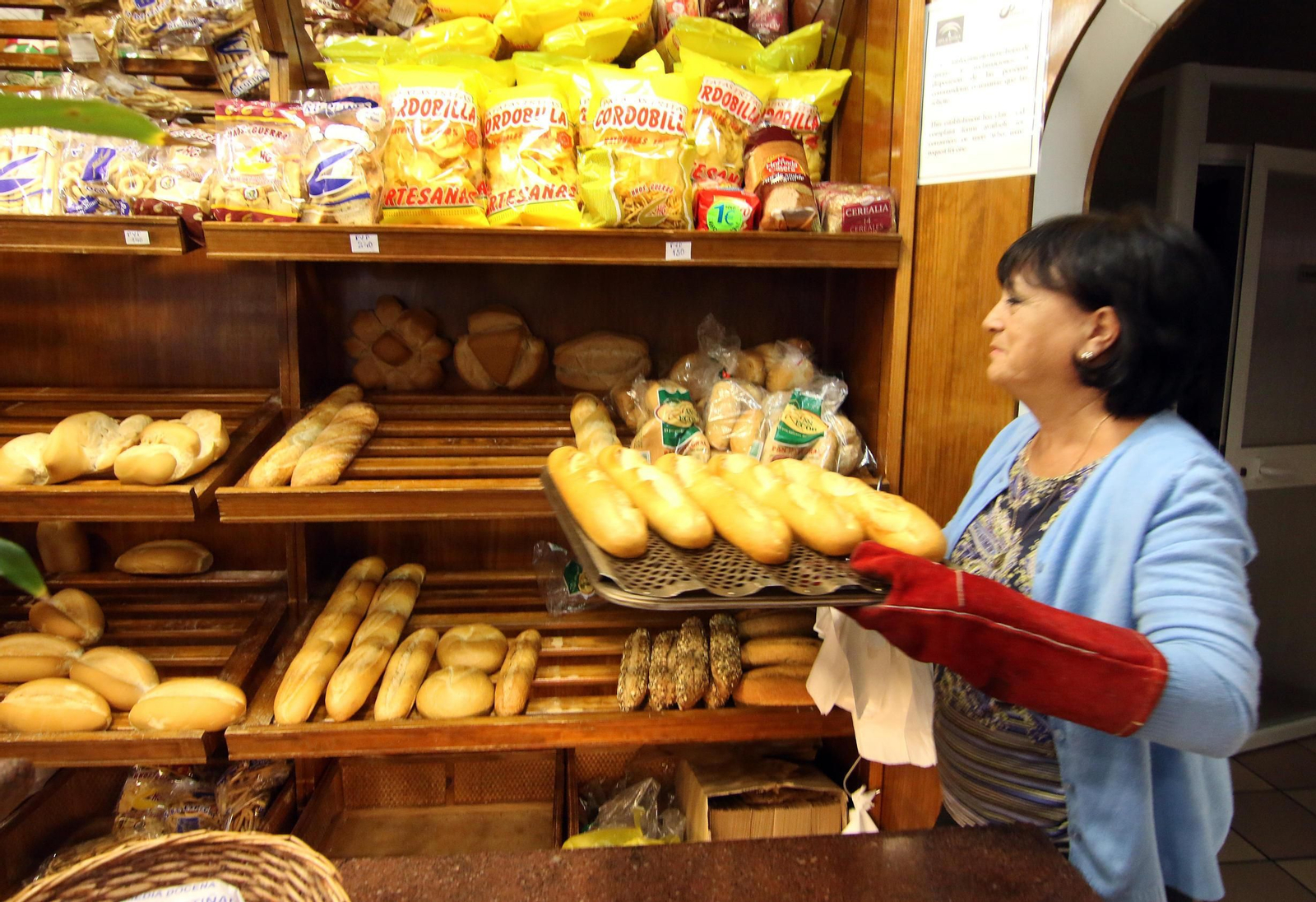 Chelo Castillejo coloca el pan recién horneado en la Cafetería Doce de Octubre.