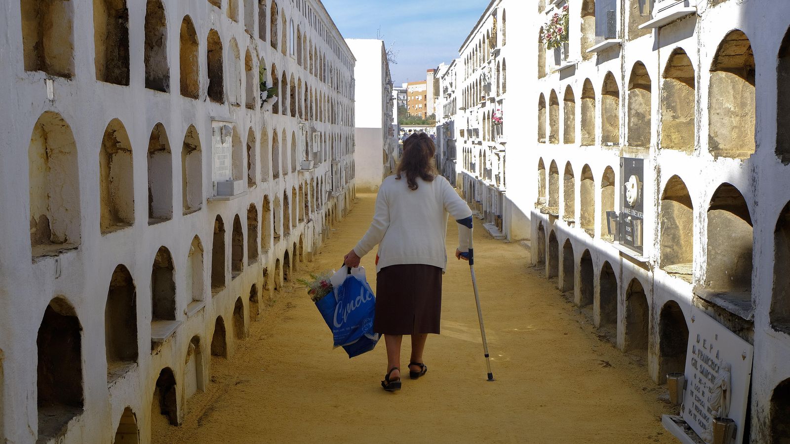 Una mujer camina entre nichos abandonados.