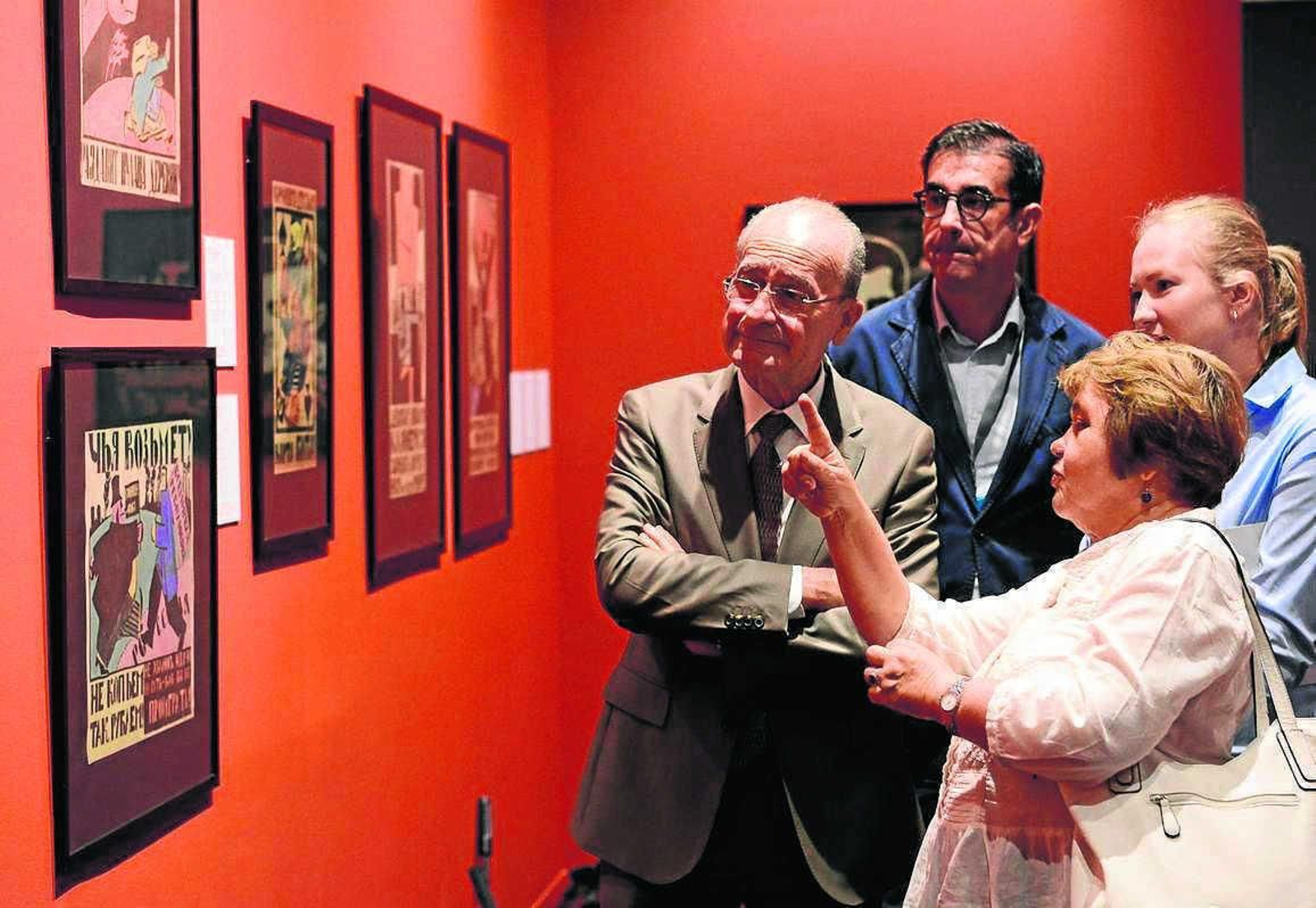 Yevguenia Petrova explica los 'Carteles de la revolución' al alcalde de Málaga junto a José María Luna.