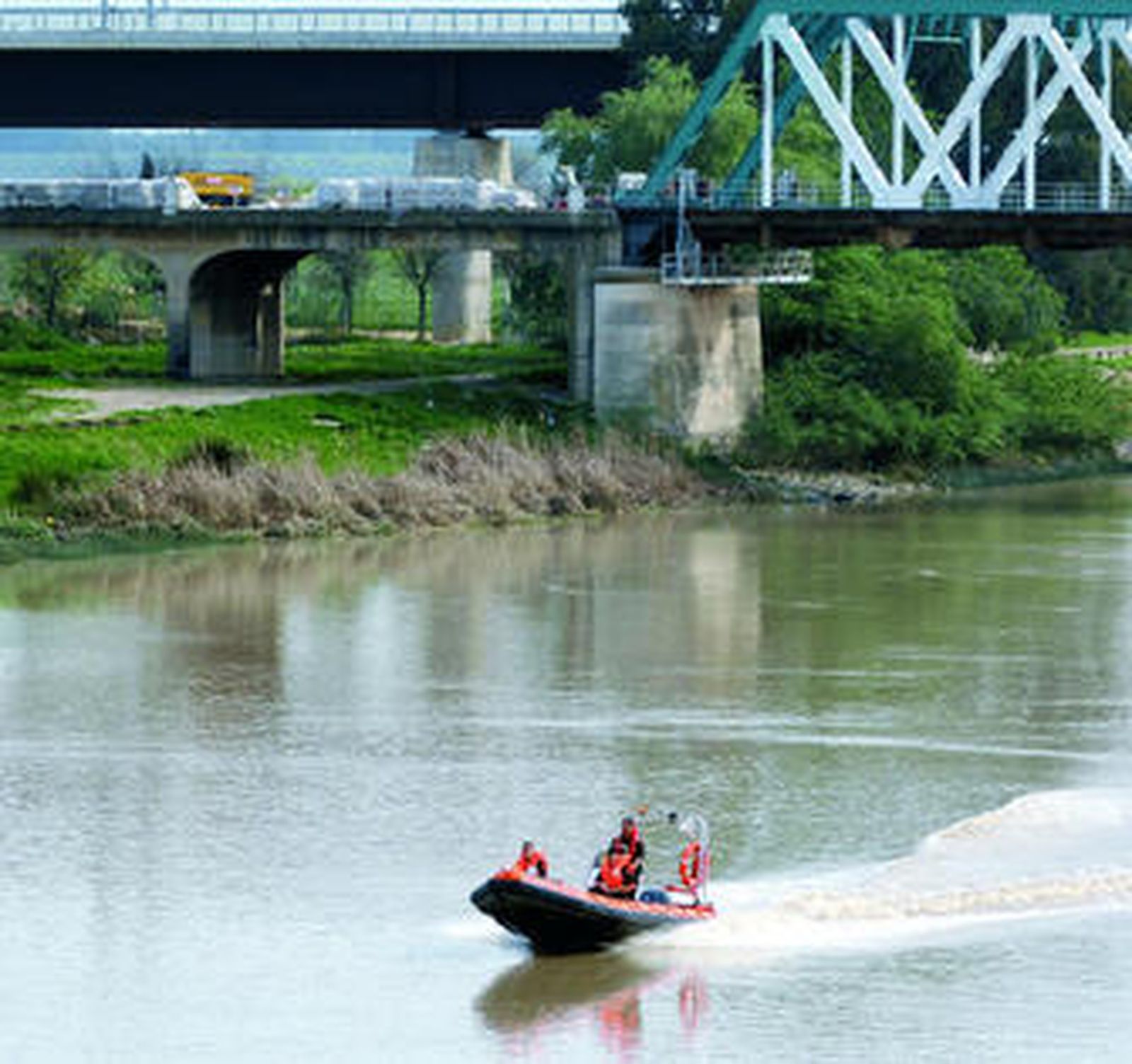 Una lancha navega por el río a la altura del puente de hierro de San Juan, ayer por la tarde.