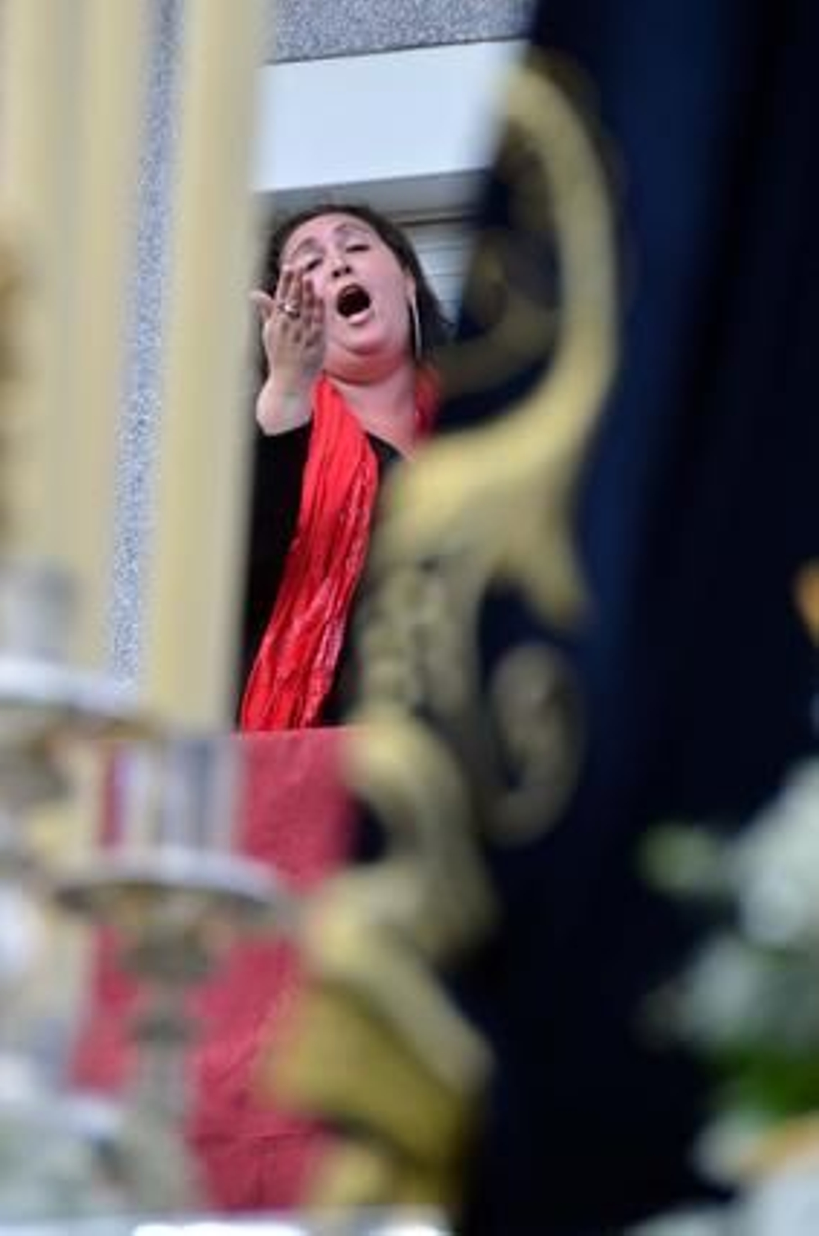 El rezo. La salida de María Santísima del Consuelo trajo consigo la saeta de una cofrade en una ventana junto a la Capilla del Pelirón.

Foto: Manuel Aranda