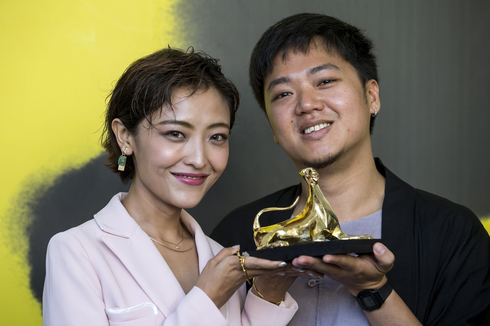 La actriz china Luna Kwok y el director de Singapur Yeo Siew Hua posan con el Leopardo de Oro.