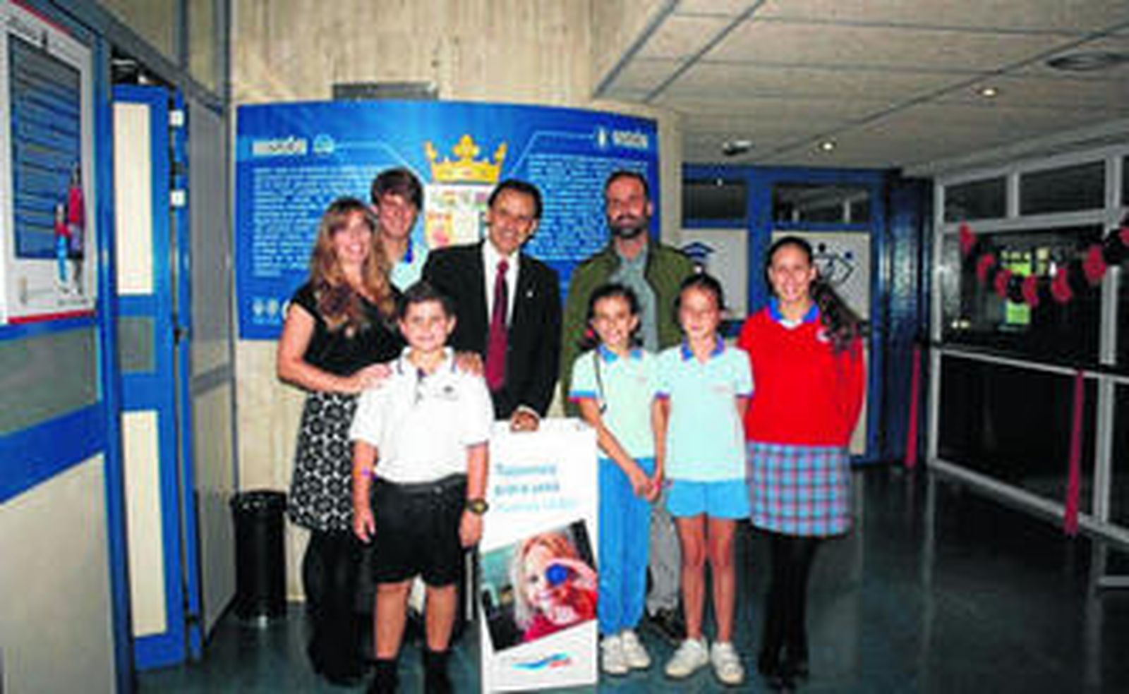 Estudiantes y profesores del colegio posan con el cartel anunciador de la campaña.