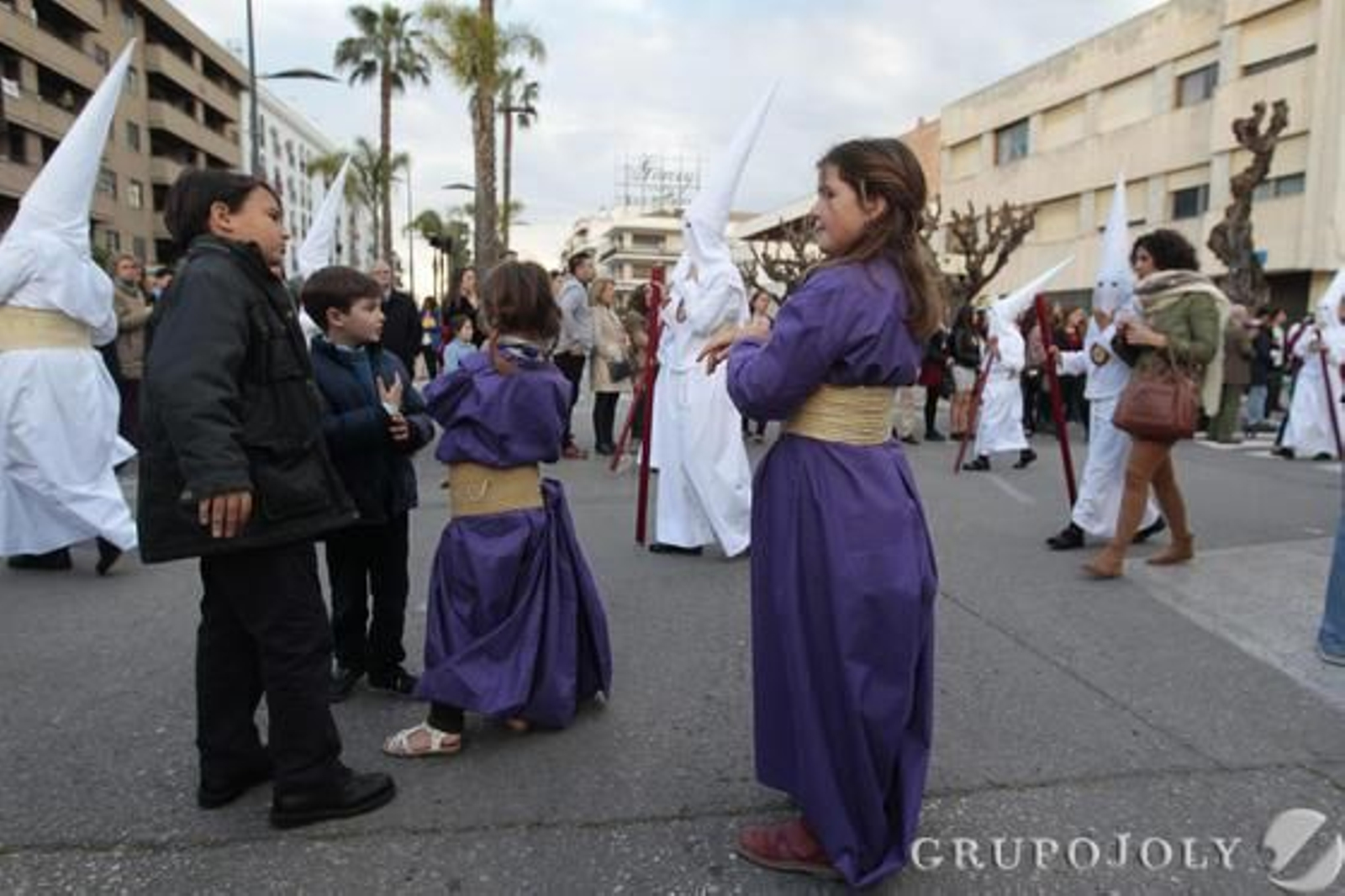 Hermanos de La Clemencia pasan ante Capuchinos mientras unas hermanas de la Defensión los ven desde fuera del templo.  Foto: Jose Contreras