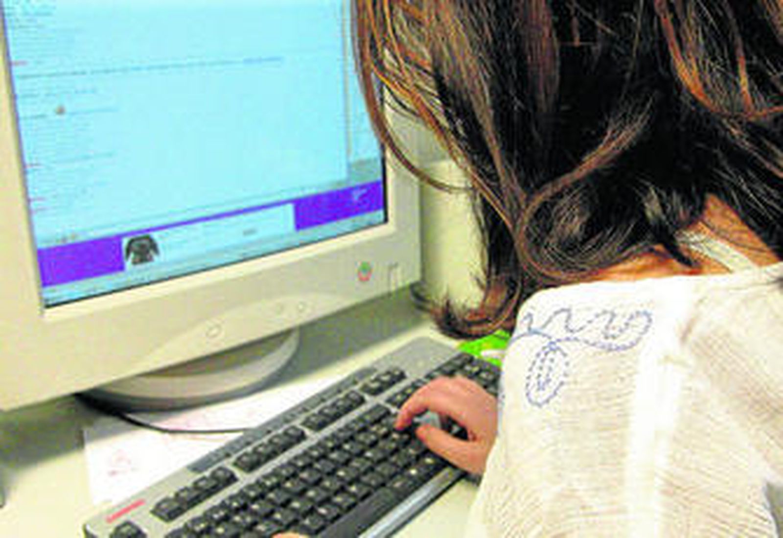 Imagen de una joven pegada a su ordenador navegando a través de internet.