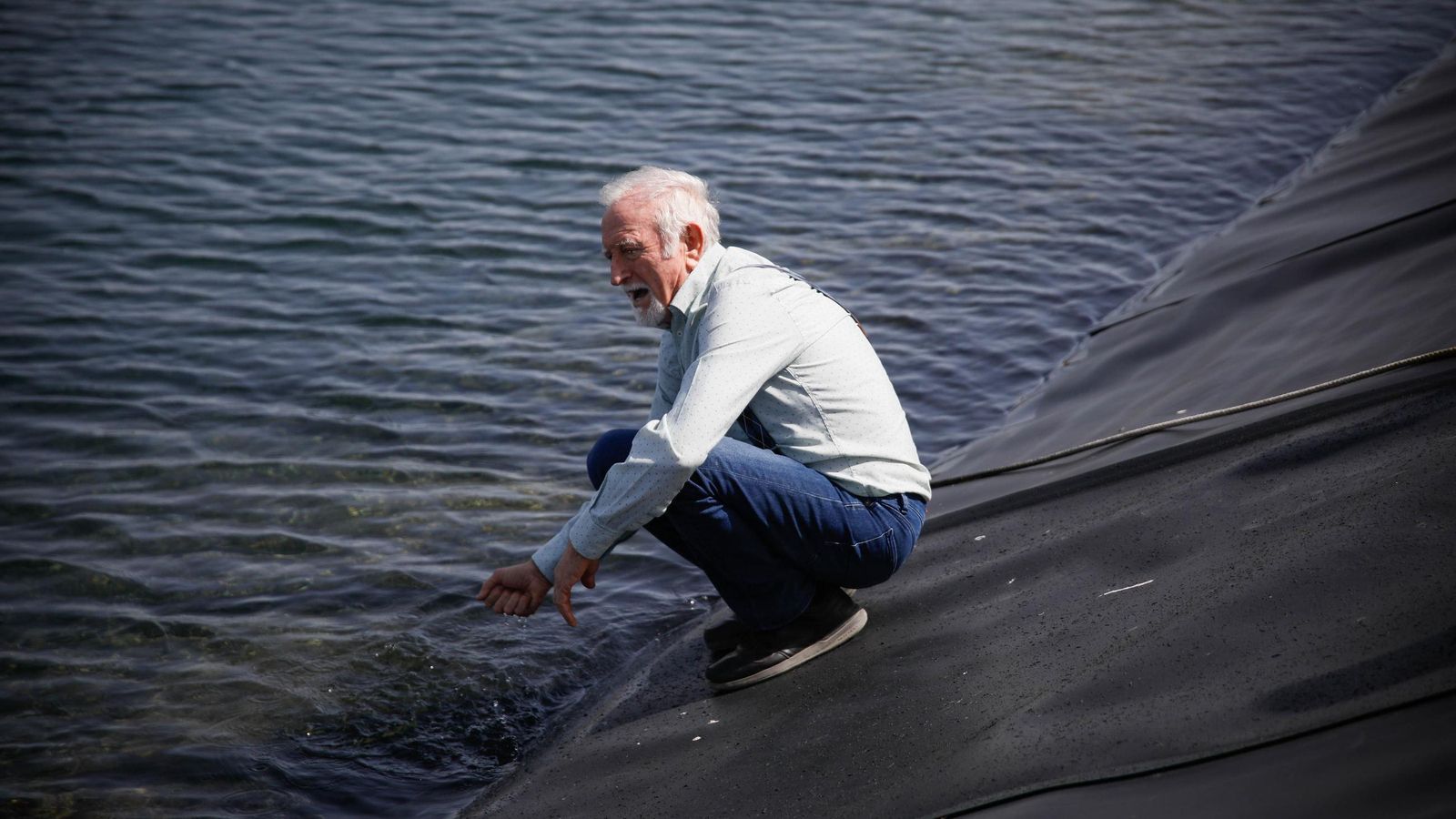 Antonio López toca el agua de una de las balsas cuando estaban llenas.