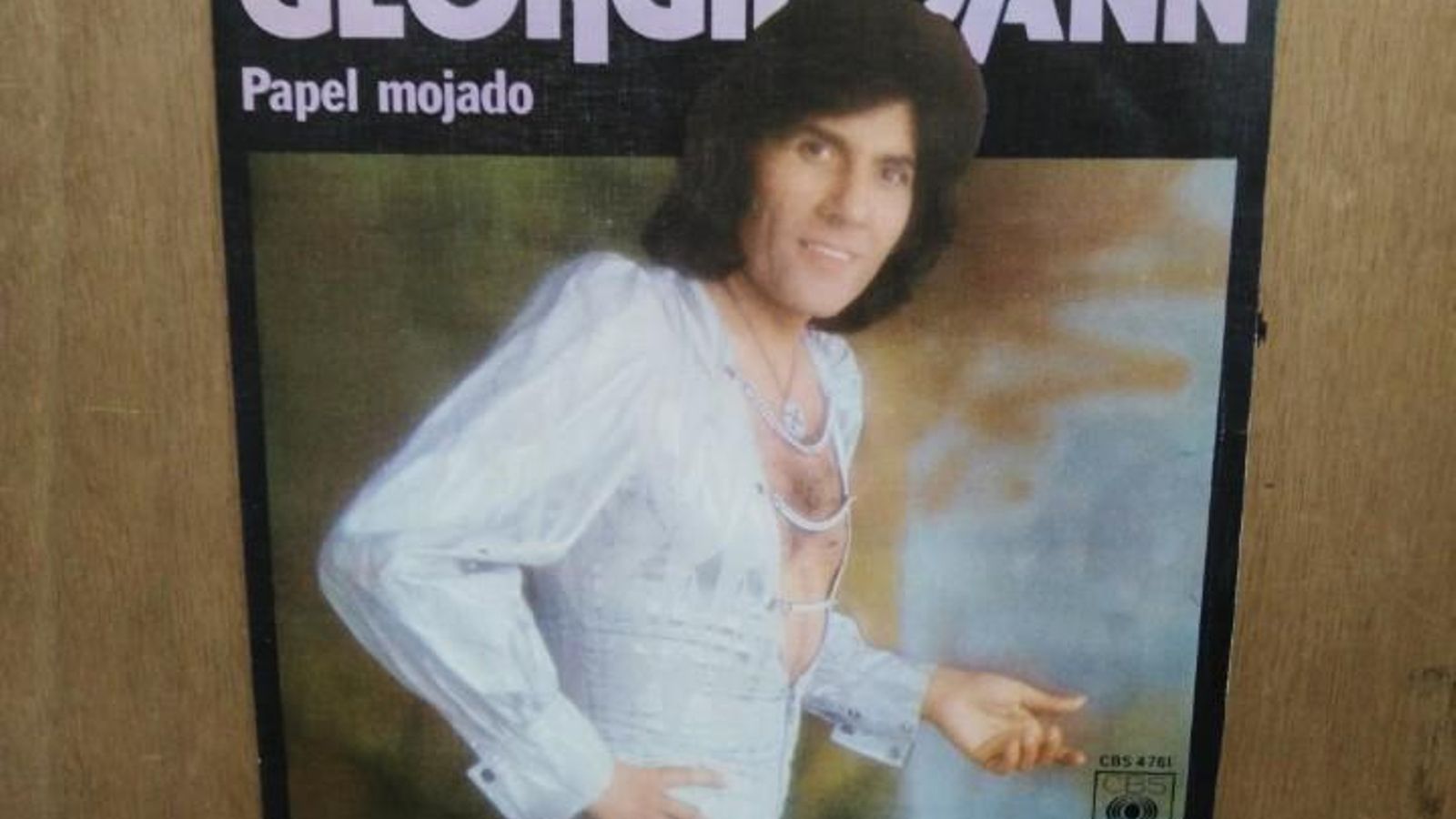 Georgie Dann, con mono blanco mostrando pelo en el pecho, en la portada de uno de sus discos.