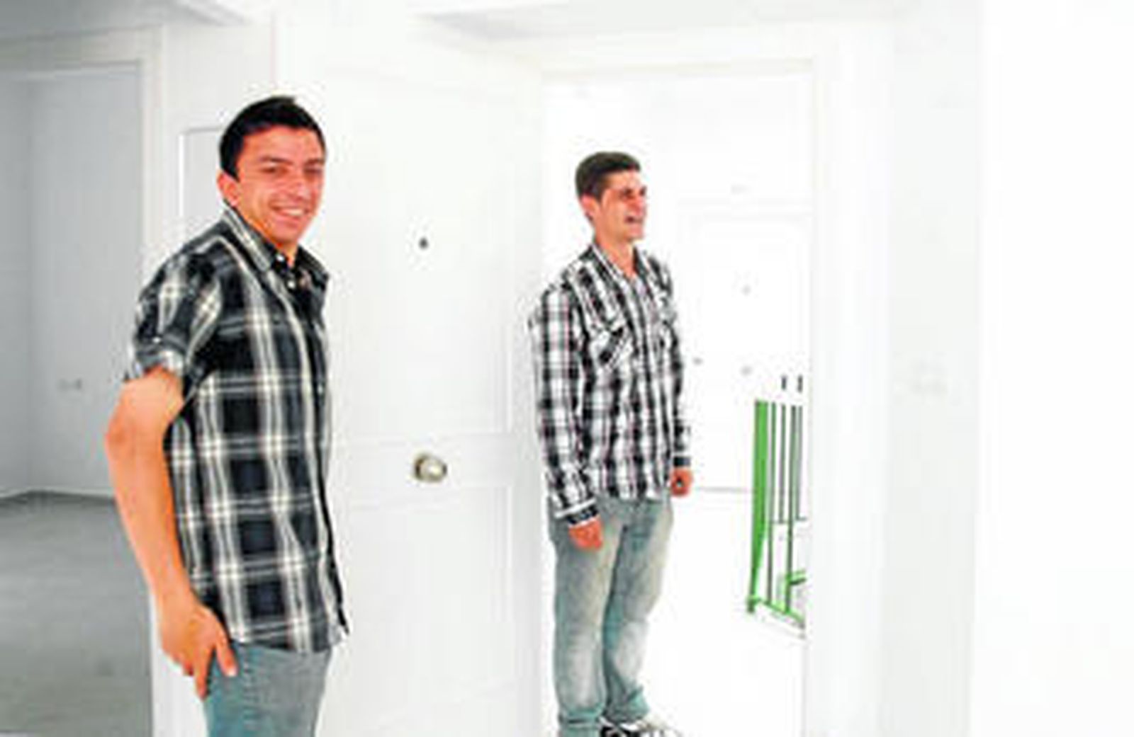 Dos jóvenes accedían a sus viviendas de Portería de Capuchinos tras serle entregadas las llaves ayer por parte de la consejera Elena Cortés.