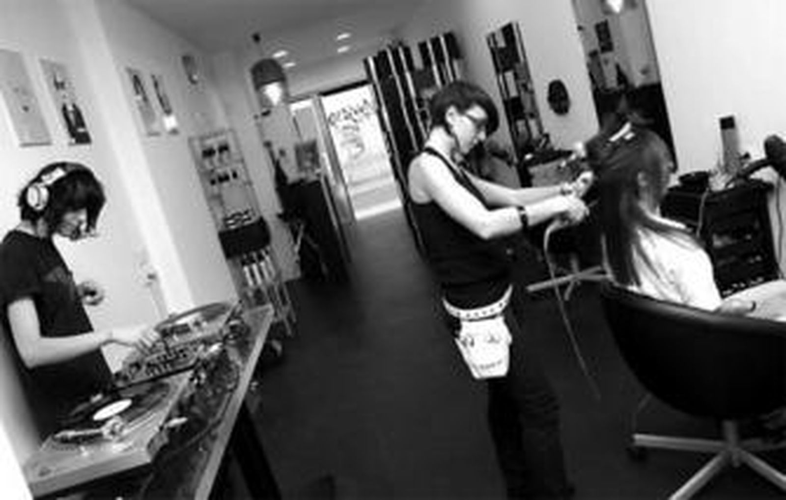 Mayte Vázquez atiende a su clientela mientras una 'dj' pincha música en su peluquería, Art-Shampoo.