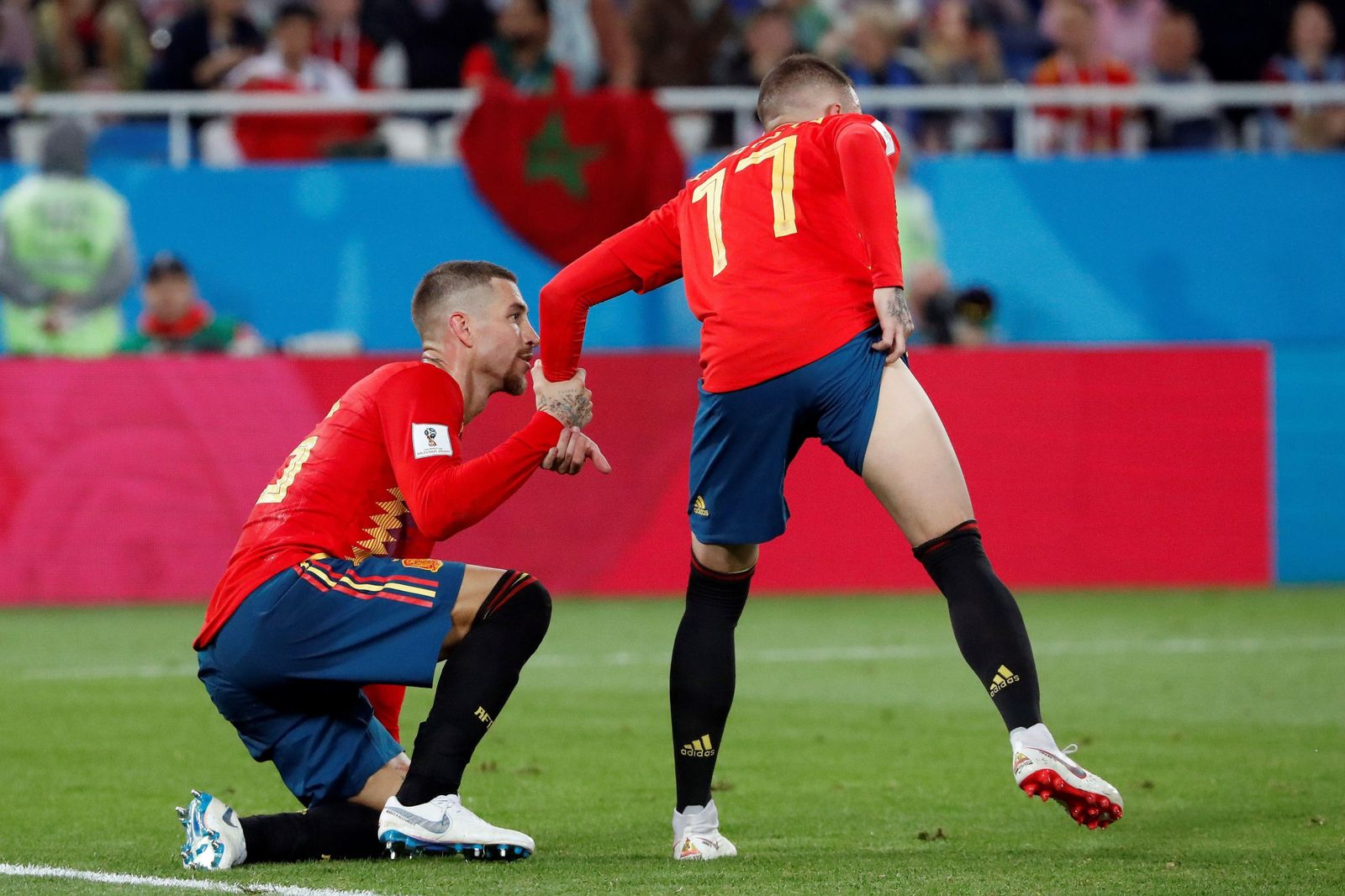 Iago Aspas levanta a Sergio Ramos tras un lance del juego.