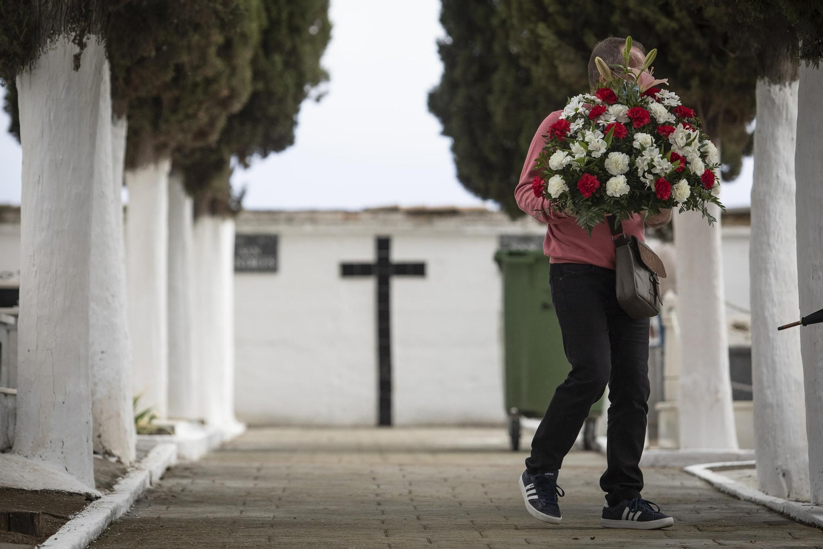 Imagen de archivo de un hombre llevando flores al cementerio de Atarfe