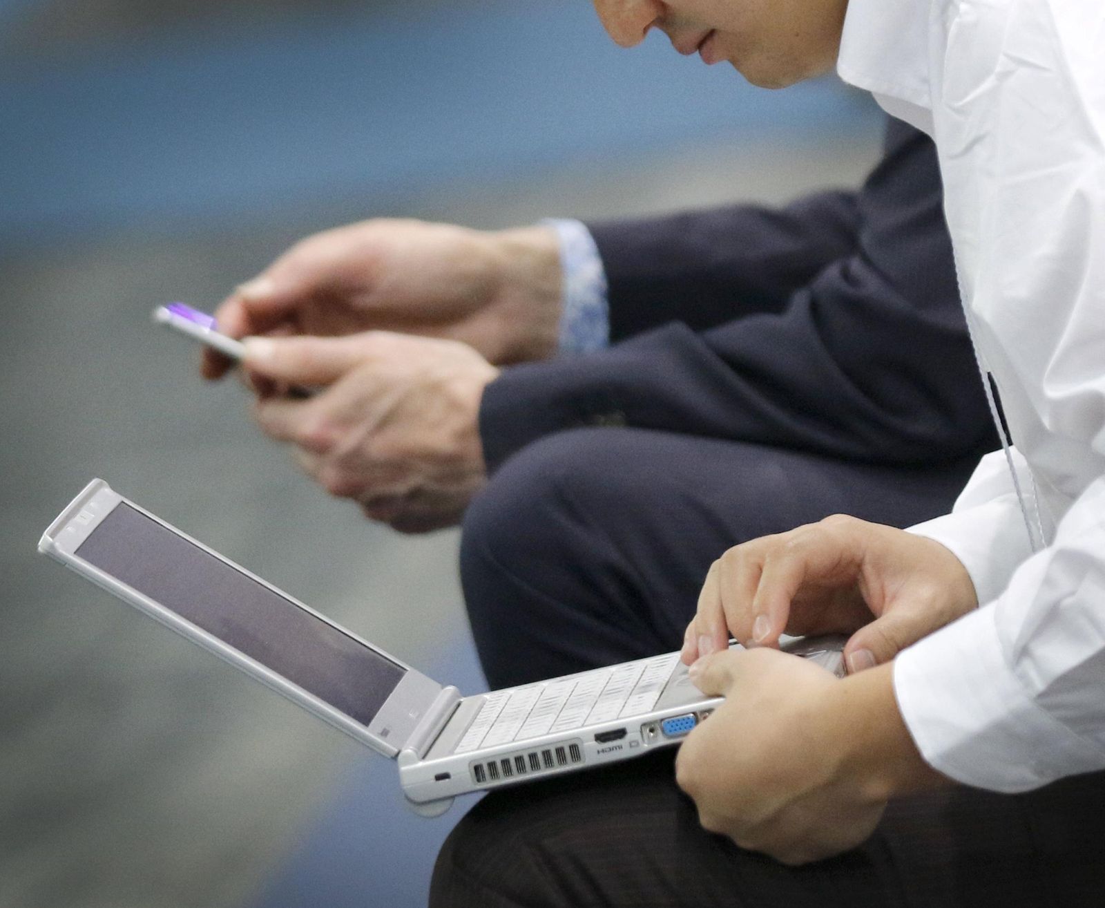 Dos personas trabajan con un ordenador y un móvil | Imagen de archivo