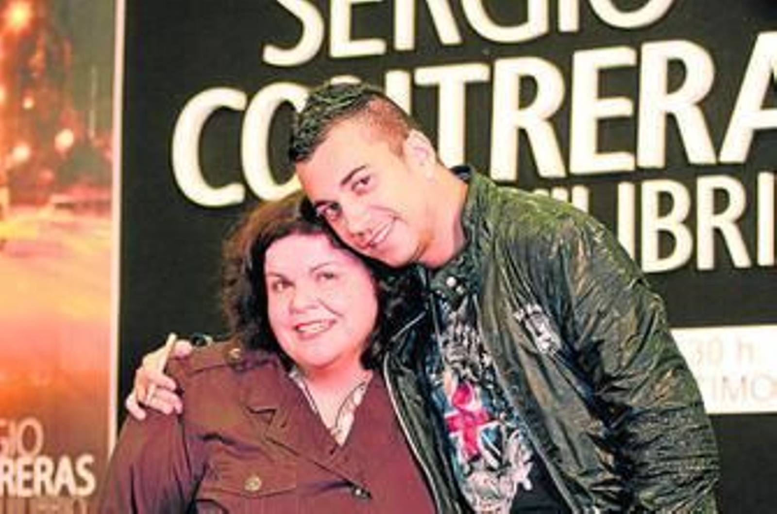 Sergio Contreras posa abrazado a una de sus fans durante su firma de discos en Huelva.