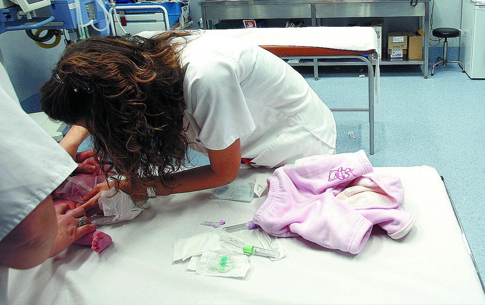 Dos profesionales sanitarios exploran a un bebé.