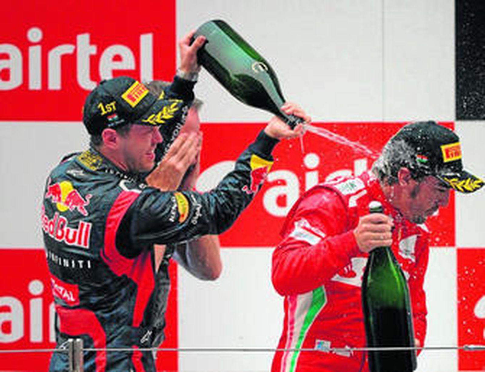 Sebastian Vettel riega con champán a Fernando Alonso en el podio del Gran Premio de la India.