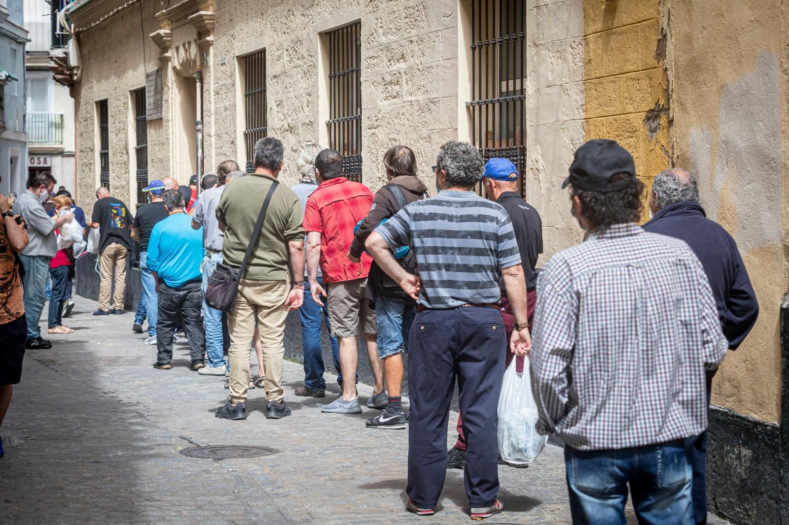 Cola de personas para recoger comida en el comedor María Arteaga de Cádiz.