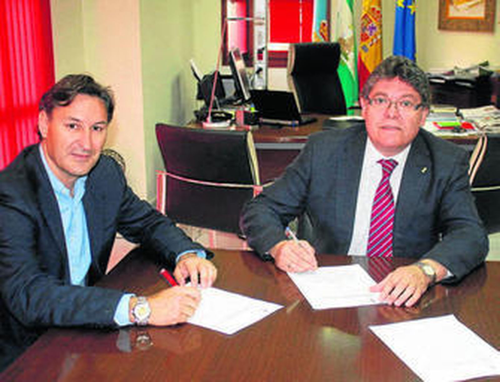 Rogelio Mena (derecha) firma con un responsable de Procosona el contrato de las obras de la piscina descubierta.