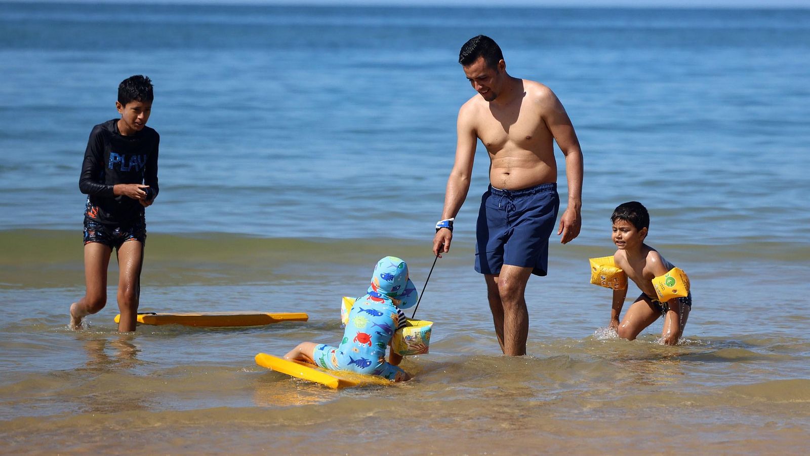 Una familia disfrutando del mar estival Una familia disfrutando del mar estival
