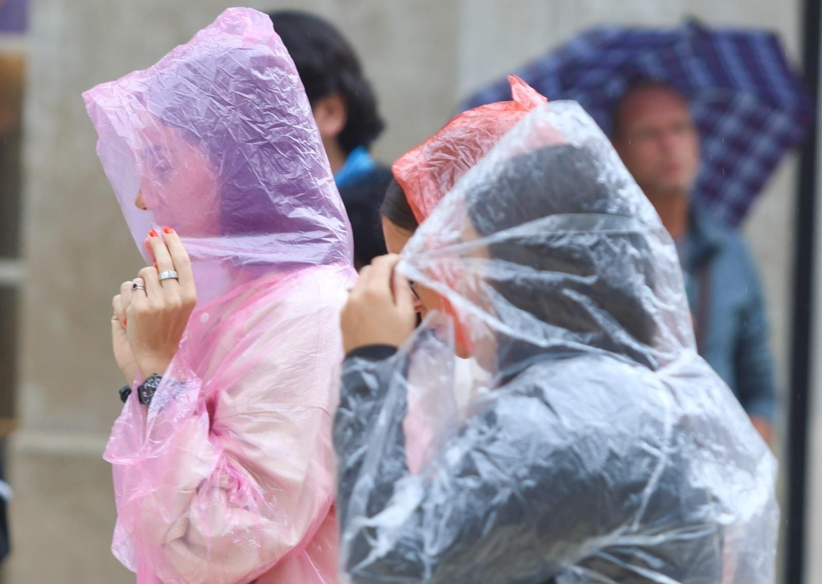 Un grupo de personas pasea con chubasqueros por Málaga