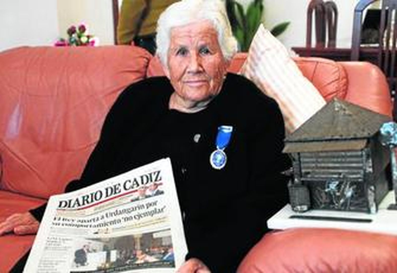 Francisca Andrades, conocida como la Calvaria, con la Medalla al Mérito en el Trabajo, con una réplica (dcha.), en metal, de su quiosco.