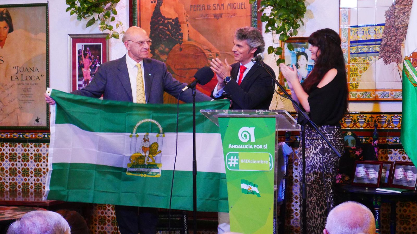 El Doctor Revuelta Soba, desplegando la Bandera de Andalucía durante el acto.