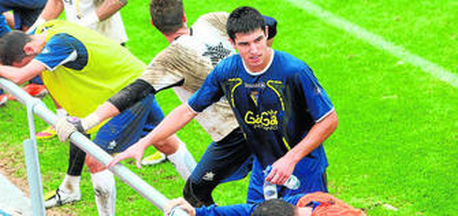 Diego González se agarra a una valla del campo principal de El Rosal para realizar unos ejercicios al término de un entrenamiento.